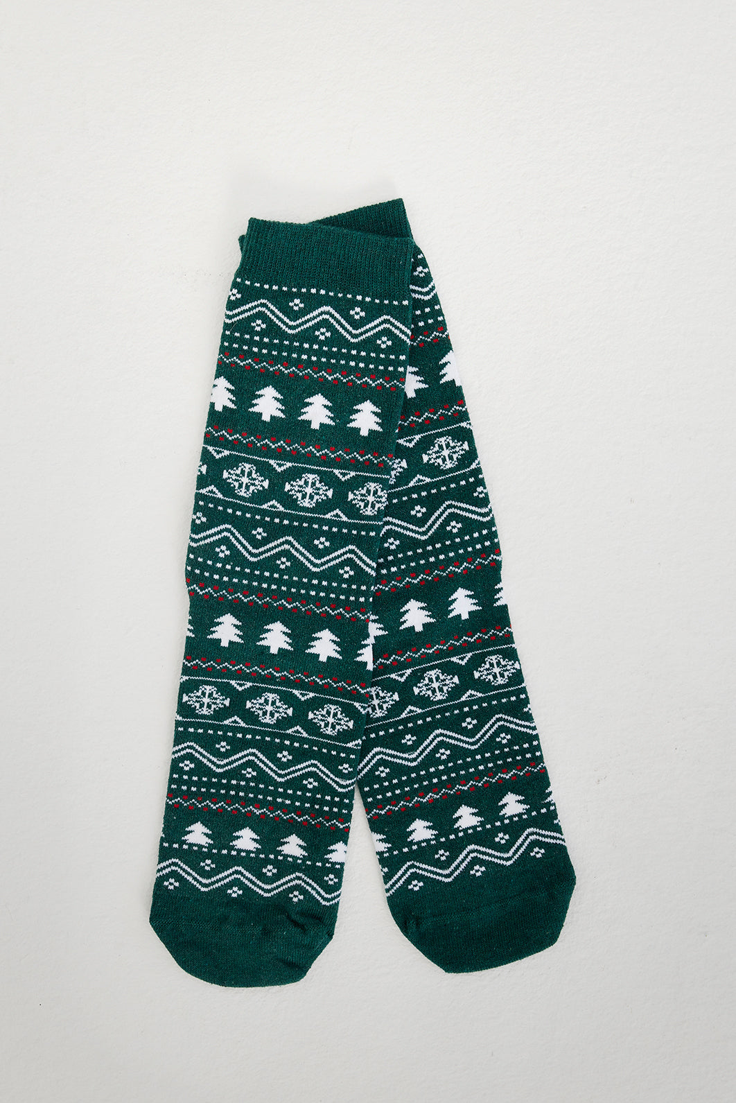 Een paar groene kerstsokken met kerstbomen erop.